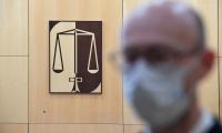      A lawyer, wearing a protective mask stands close to a scales of justice logo. ©AFP_Damien MEYER    Механизмът за върховенството на закона беше приет на 16 декември и е правнообвързващ за всички, включително за ДЧ и Комисията